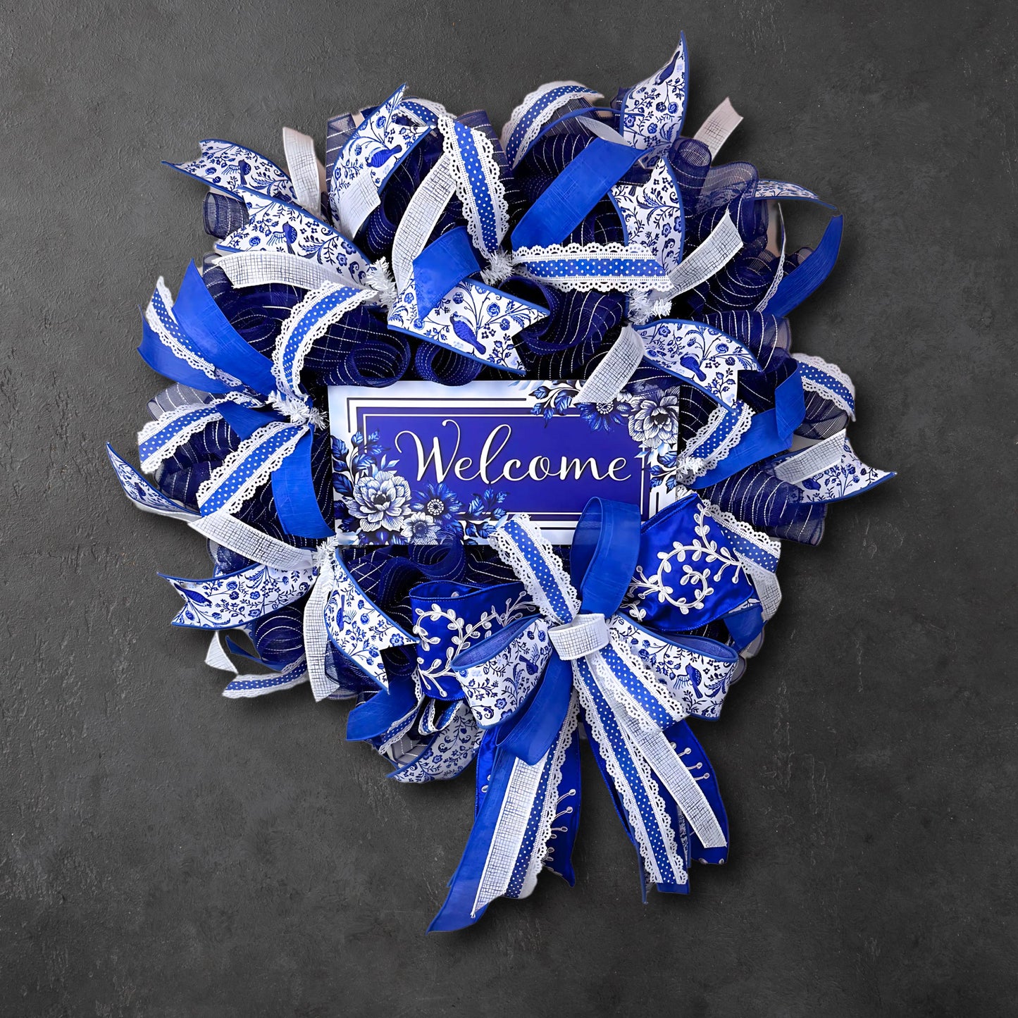 Handmade chinoiserie-style welcome wreath with blue and white designer ribbon and mesh, perfect for front door decor.