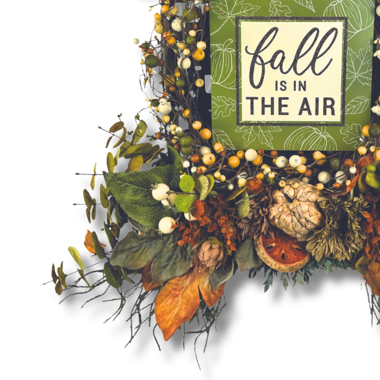 Detailed shot of fall wreath leaves, cream berries, and dried orange slice for autumn texture