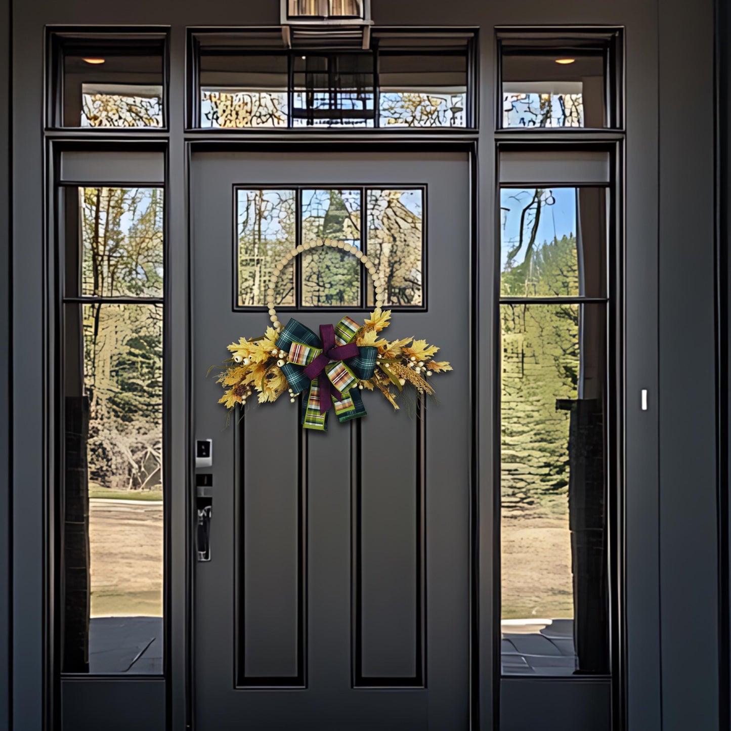 Fall hoop wreath hanging on a dark front door, showcasing seasonal home decor with rustic charm.