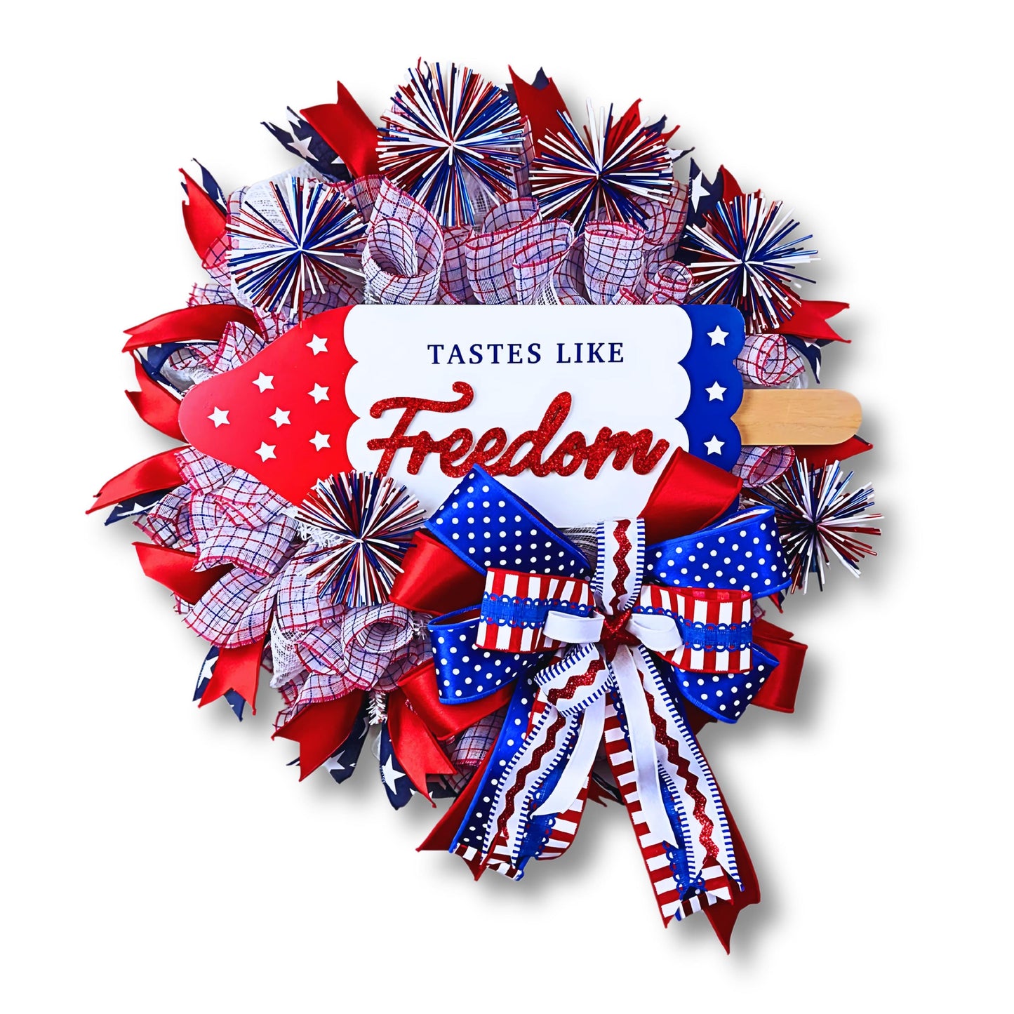 Handmade 4th of July door wreath with red white and blue mesh and ribbon, popsicle sign that says Tastes Like Freedom, perfect for patriotic home decor