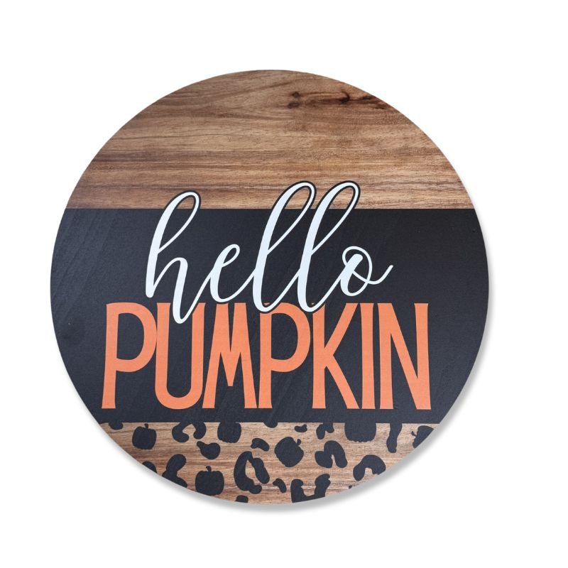 Rustic round "Hello Pumpkin" door hanger with leopard print and durable birch wood construction, perfect for welcoming fall with a stylish touch.