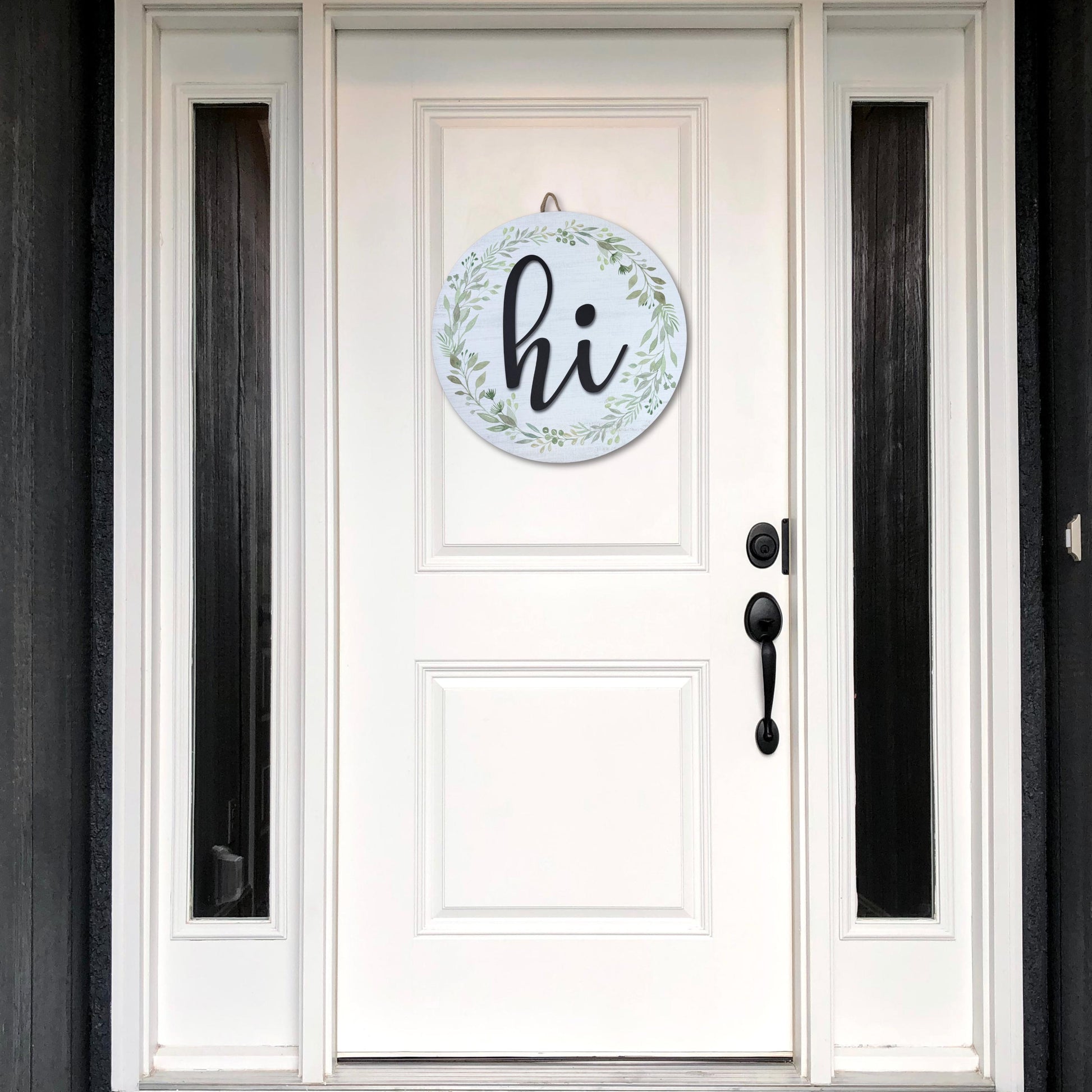 White door with black trim featuring round hi door sign with greenery wreath, modern farmhouse entryway decor for welcoming guests