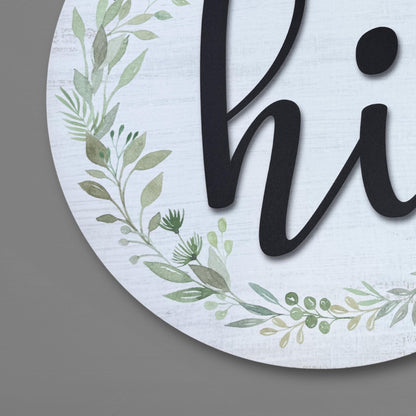 Close-up detail of watercolor greenery wreath and 3D black hi lettering on round door sign, showing intricate botanical artwork