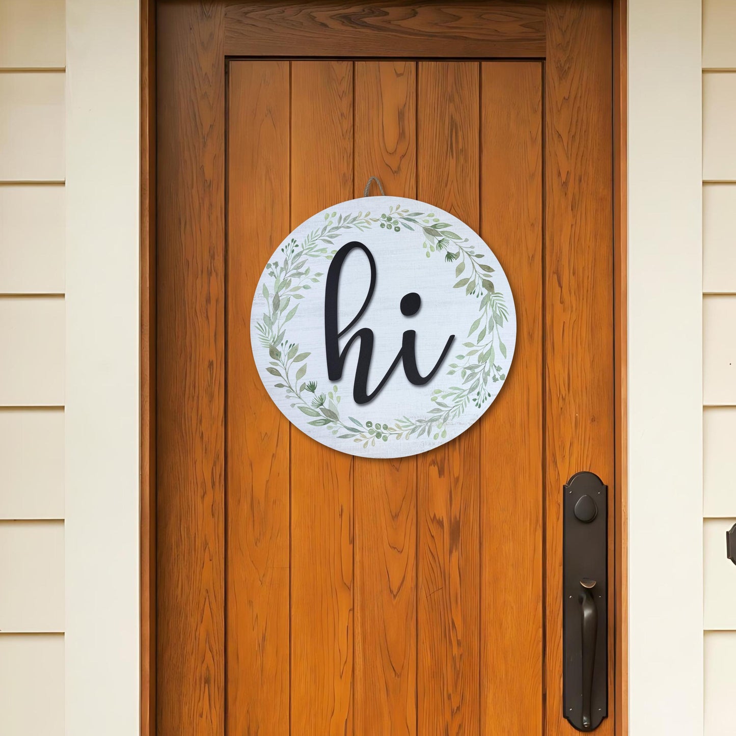 Round hi door sign with greenery wreath hanging on natural wood front door, showcasing farmhouse entryway decor styling