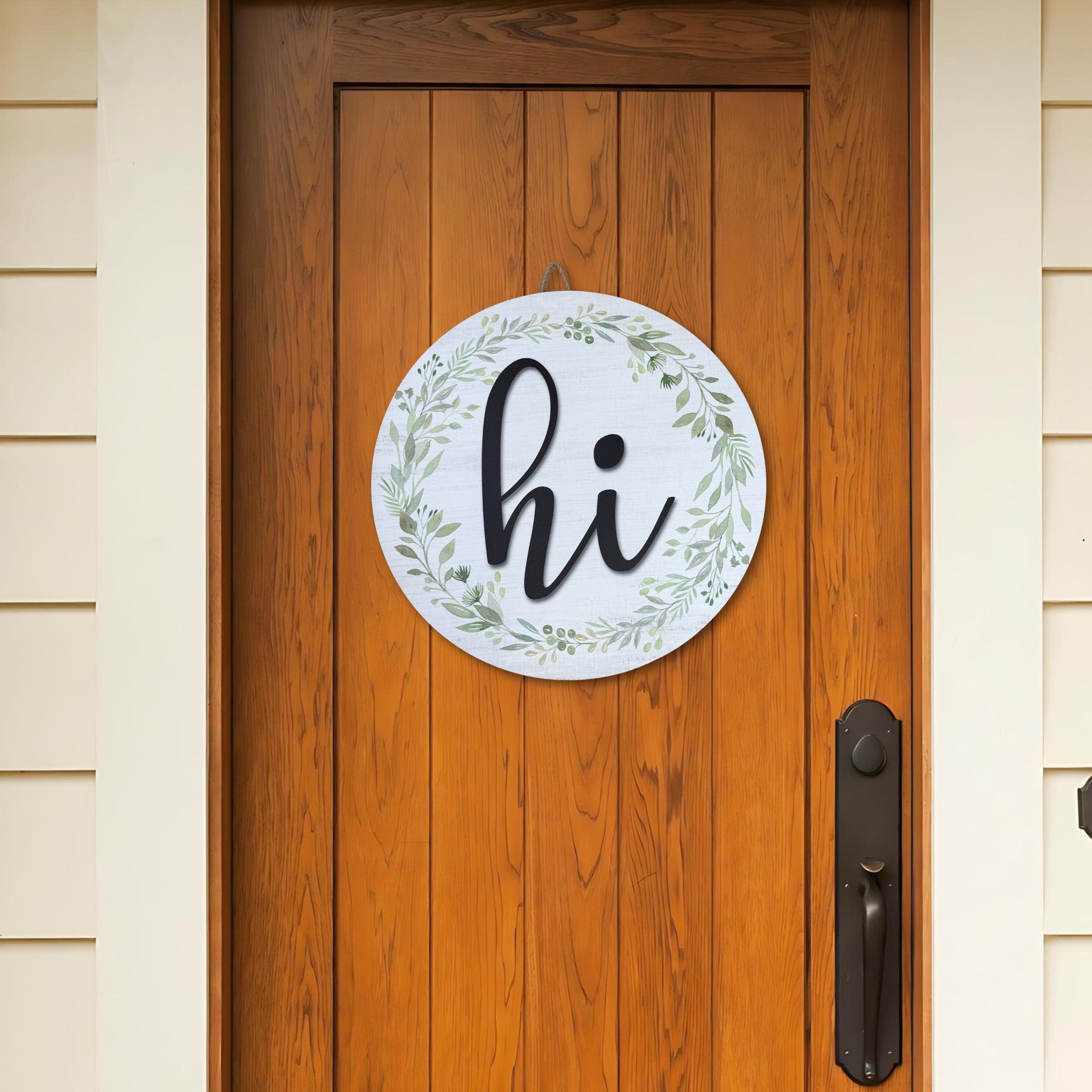 Round hi door sign with greenery wreath hanging on natural wood front door, showcasing farmhouse entryway decor styling