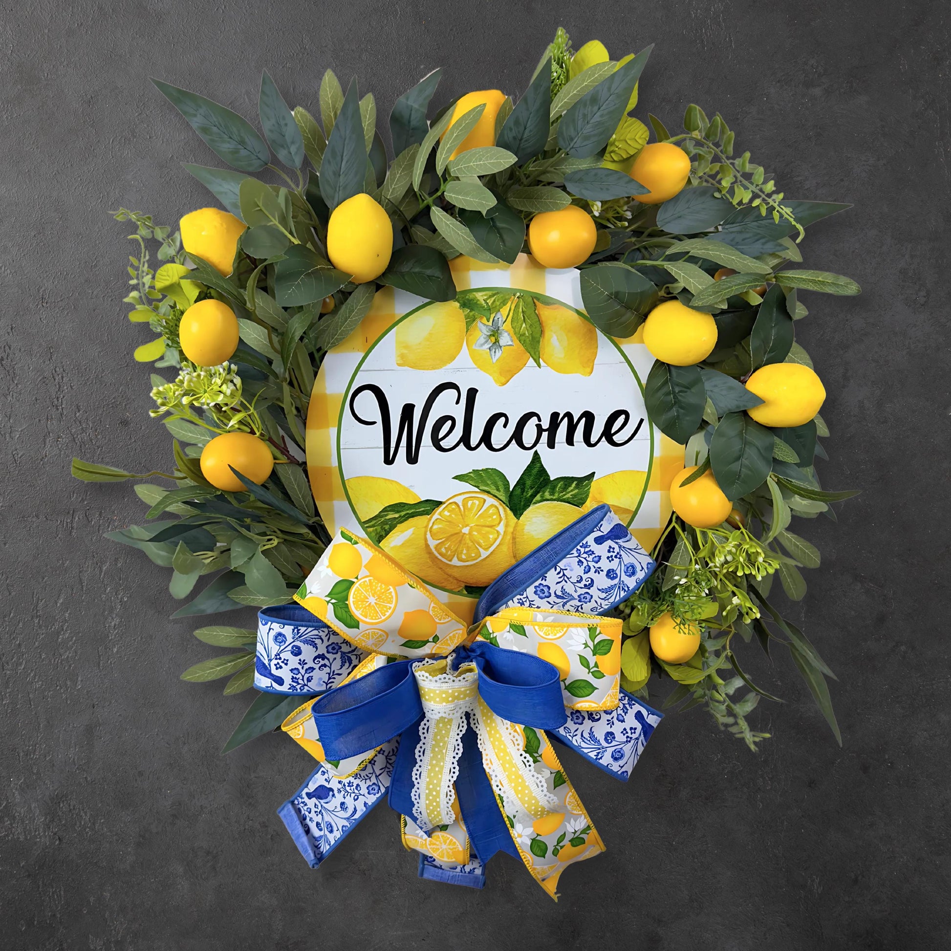 Handmade lemon welcome wreath with faux lemons, greenery, and layered blue and yellow bow, perfect for front door summer decor