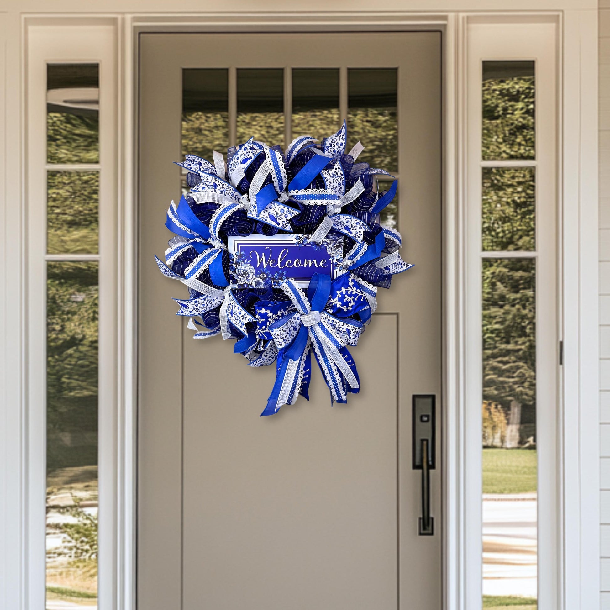 Elegant chinoiserie welcome wreath with blue and white floral ribbon displayed on front door, perfect for porch decor or entryway accent.