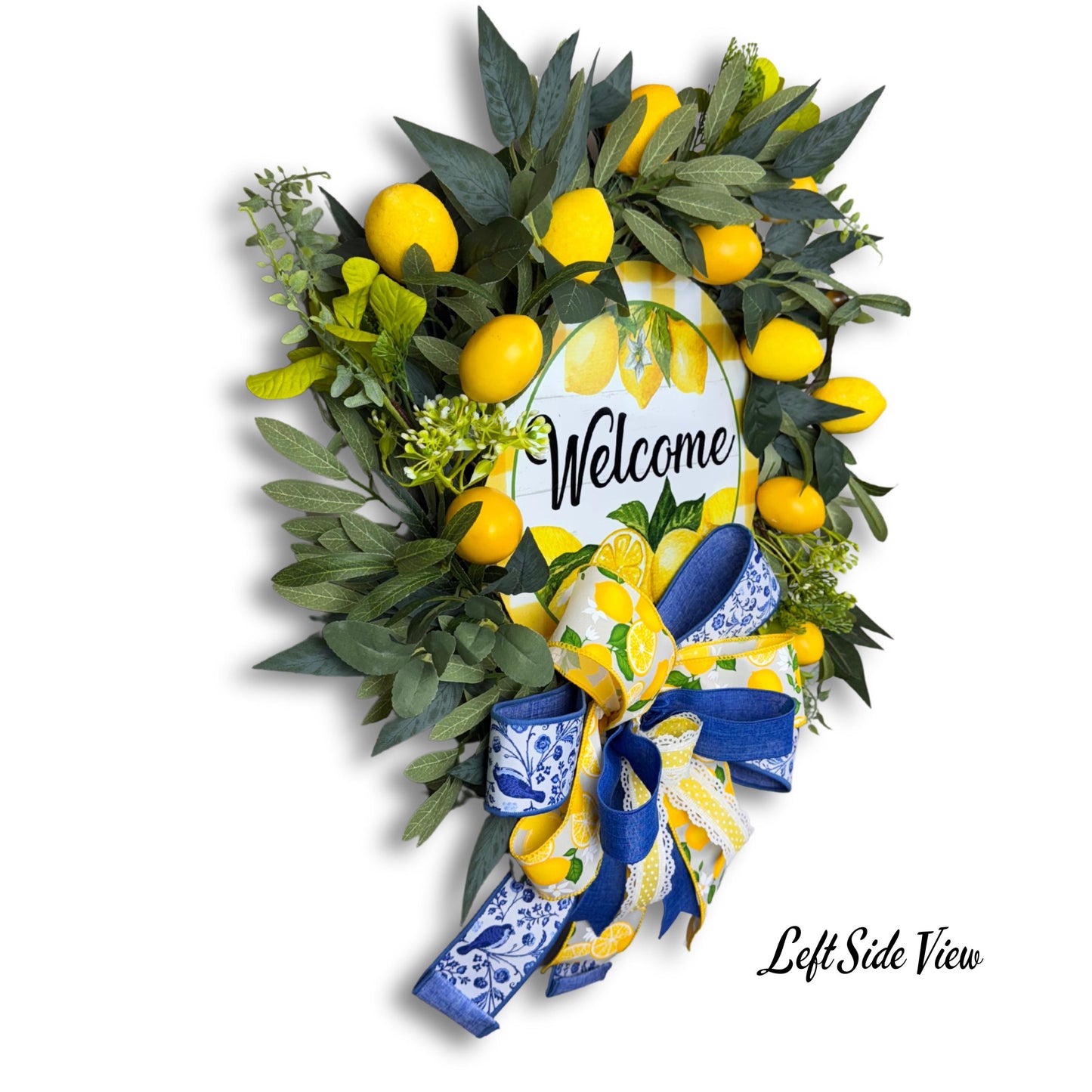 Left side angle of lemon wreath with welcome sign, showcasing textured ribbon, vibrant lemons, and full greenery coverage